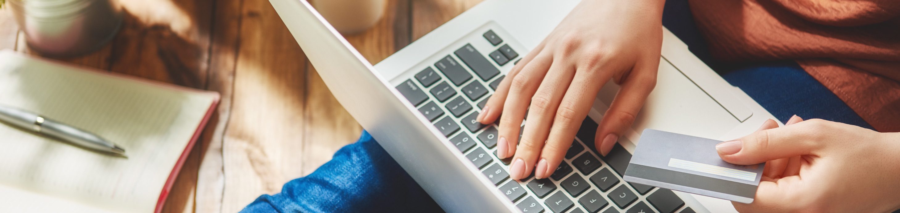 Person holding a credit card with a laptop